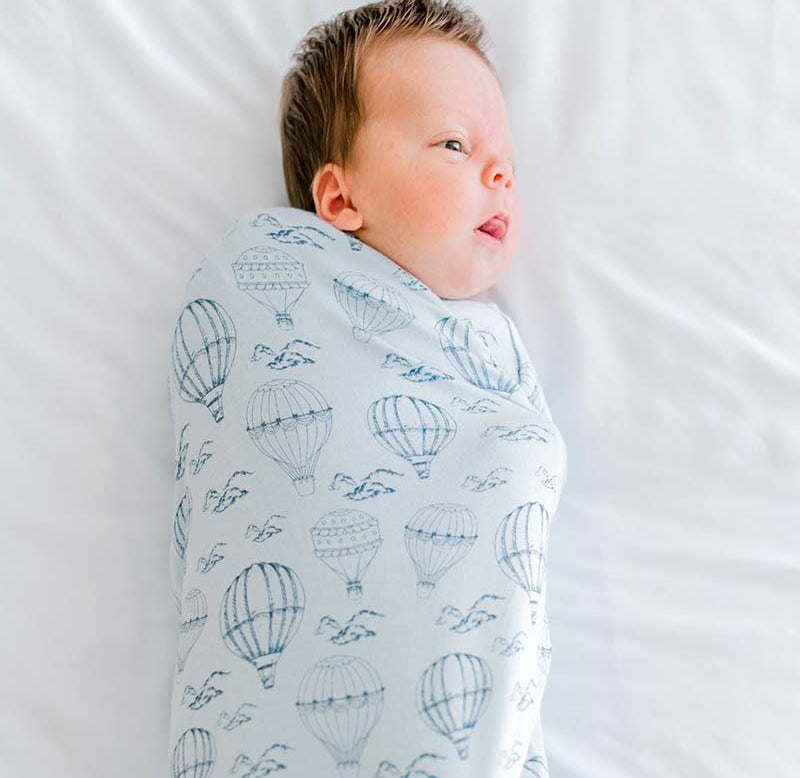 Baby cocoon swaddle featuring our bon voyage design, made from bamboo cotton fabric.