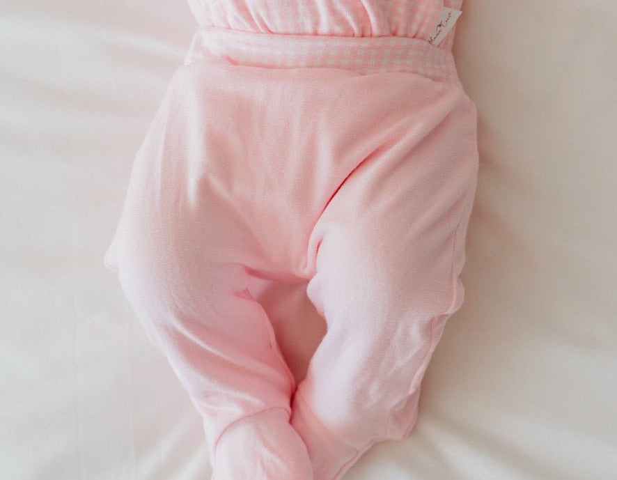 Reversible baby footie pants in pink gingham design.