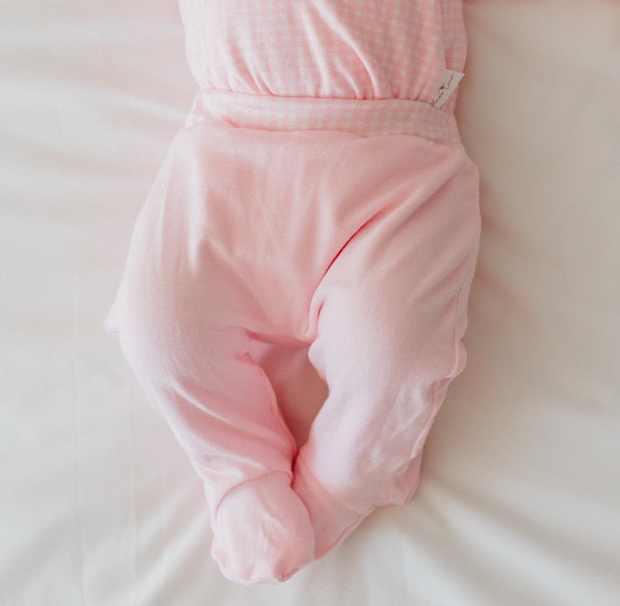 Reversible baby footie pants in pink gingham design.