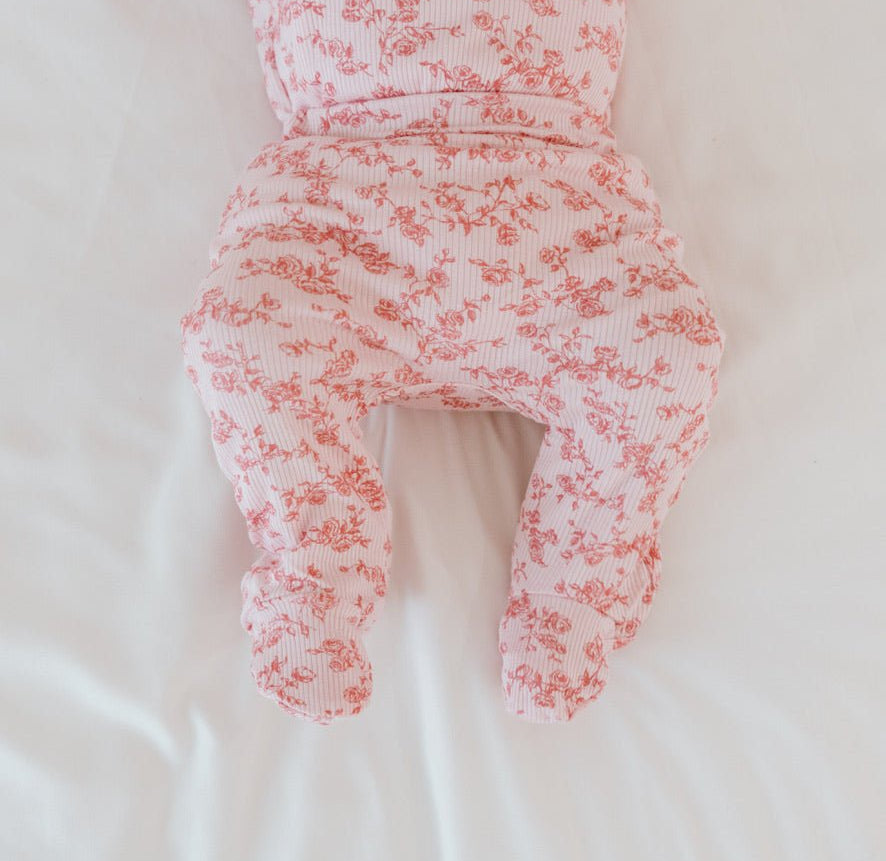 Baby footie pants in bitty pink blooms design.