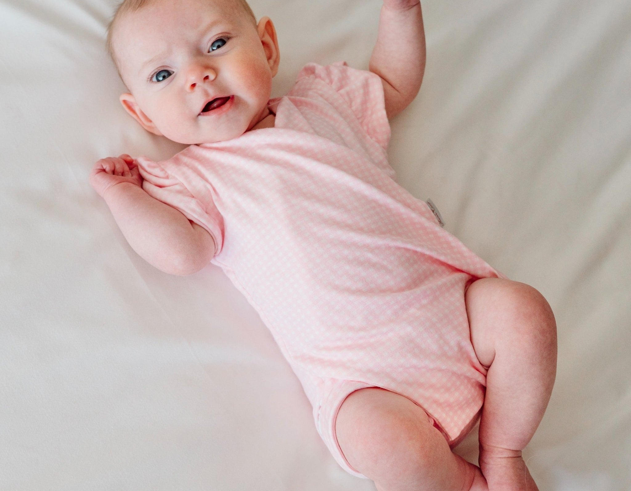 Baby pink gingham design flutter sleeve baby onesie in silky modal fabric.