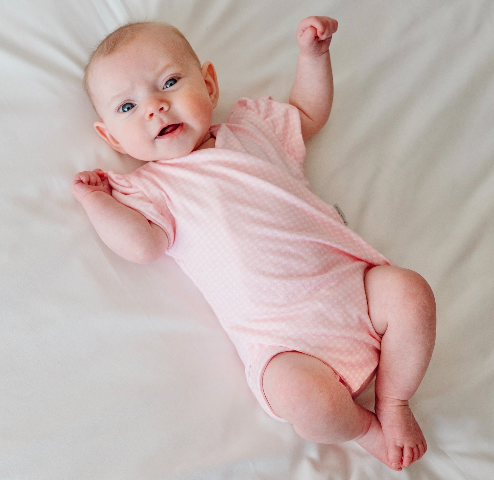 Baby pink gingham design flutter sleeve baby onesie in silky modal fabric.