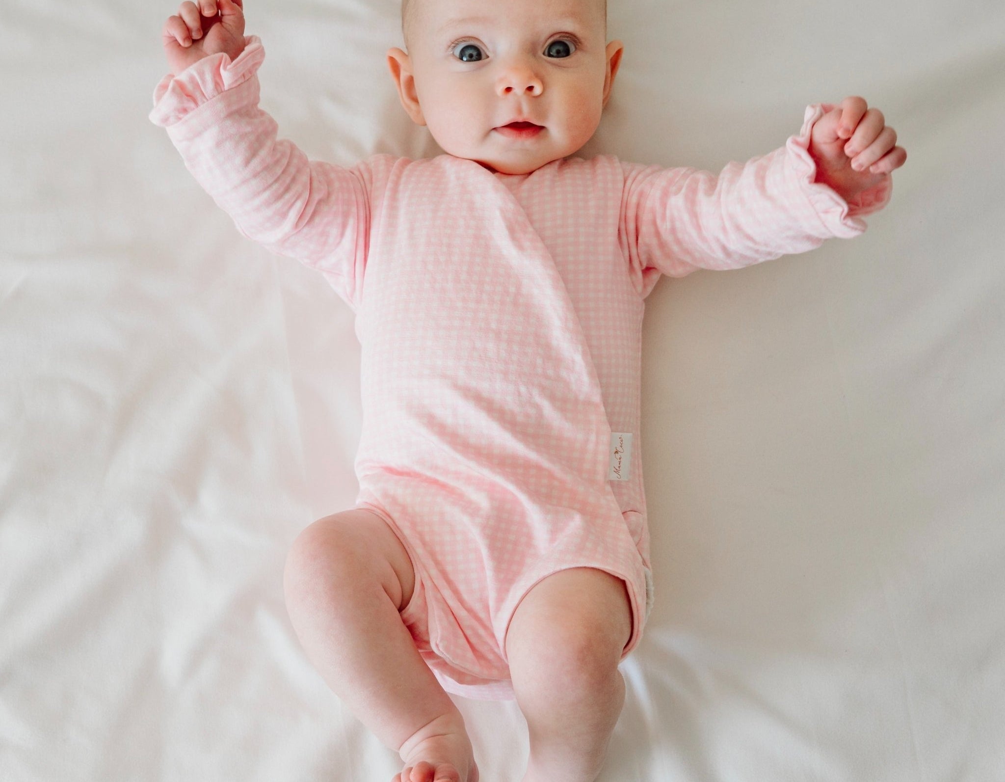 Baby pink gingham long sleeve newborn onesie, with adorable ruffle cuffs.