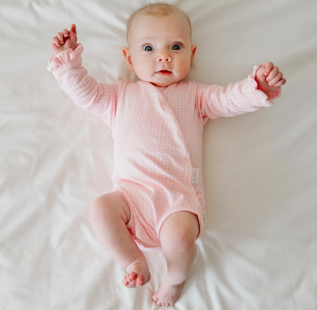 Baby pink gingham long sleeve newborn onesie, with adorable ruffle cuffs.