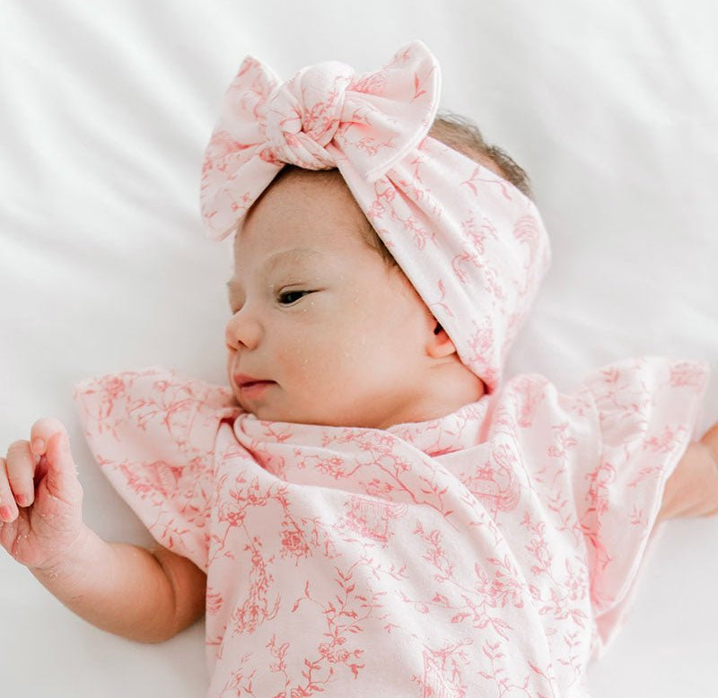 Cute baby bow headwrap made with bamboo and organic cotton fabric featuring a whimsical garden pattern.