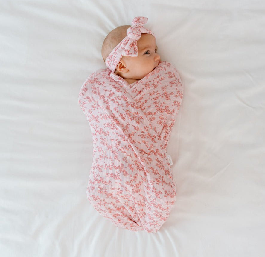 Bitty Pink Blooms Cocoon swaddle baby blanket in Silky Modal fabric styles with floral charm.