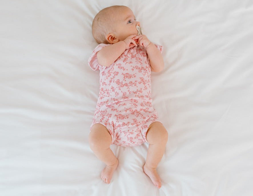 Bitty pink blooms design flutter sleeve baby onesie in silky modal fabric.