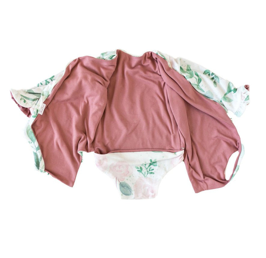 Baby long sleeve bodysuit in Blushing Eucalyptus design brushed fabric featuring wing shoulder details and ruffle cuffs.