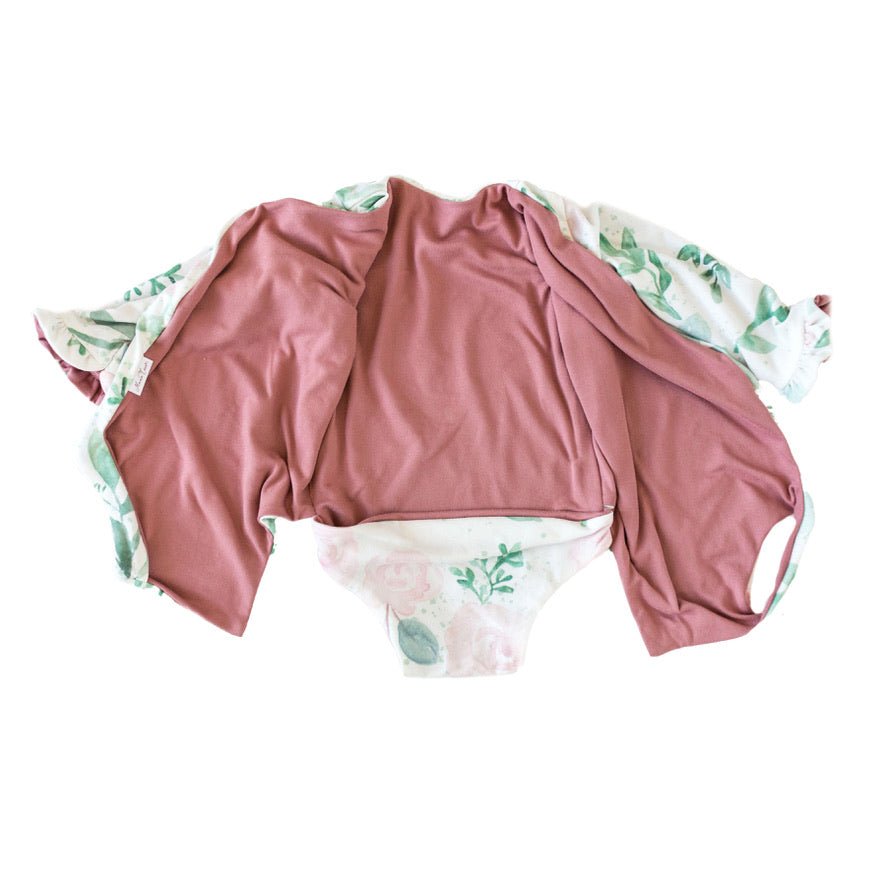 Baby long sleeve bodysuit in Blushing Eucalyptus design brushed fabric featuring wing shoulder details and ruffle cuffs.