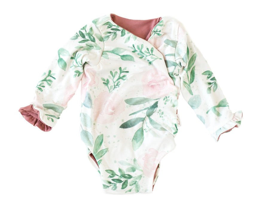 Reversible blushing eucalyptus long sleeve ruffle cuff baby onesie.