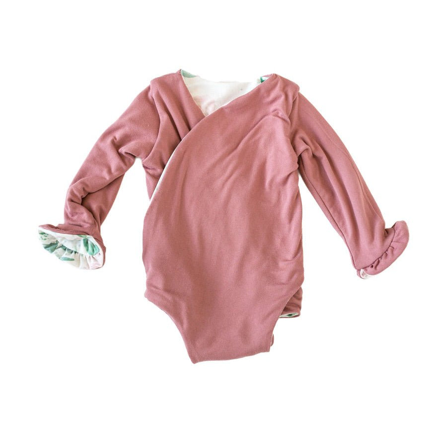 Winged long sleeve infant bodysuit crafted from cozy Blushing Eucalyptus design brushed fabric with ruffle cuffs.