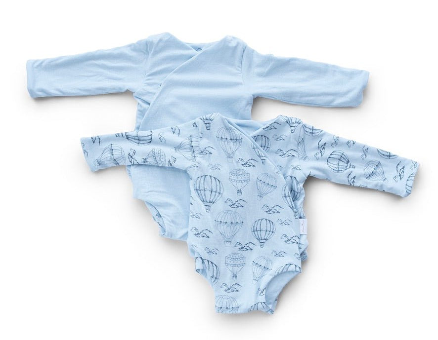 Reversible bon voyage long sleeve ruffle cuff baby onesie.