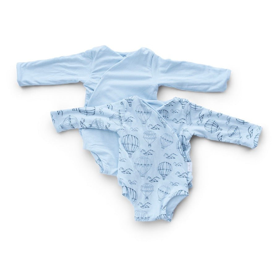 Reversible bon voyage long sleeve ruffle cuff baby onesie.