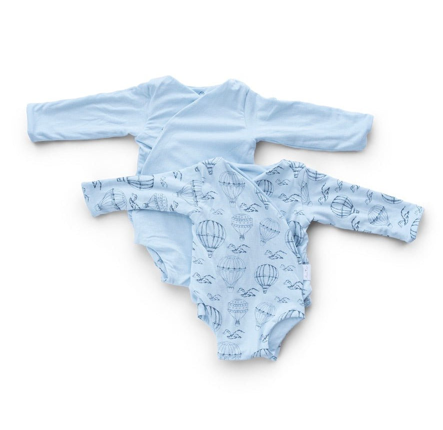 Reversible bon voyage long sleeve ruffle cuff baby onesie.