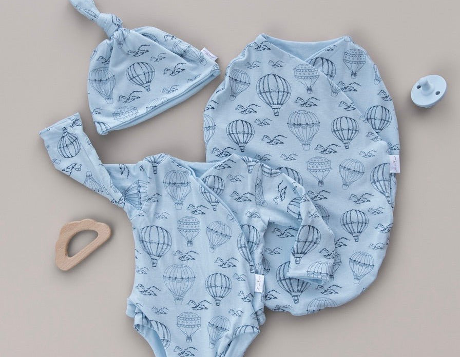 Bon voyage newborn essentials bundle. Featuring cozy long sleeves and sweet ruffle cuffs in whimsical garden design.