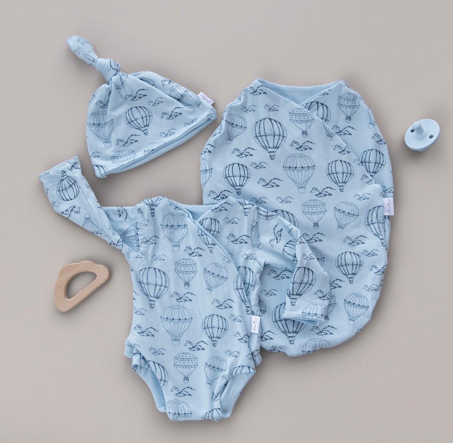 Bon voyage newborn essentials bundle. Featuring cozy long sleeves and sweet ruffle cuffs in whimsical garden design.