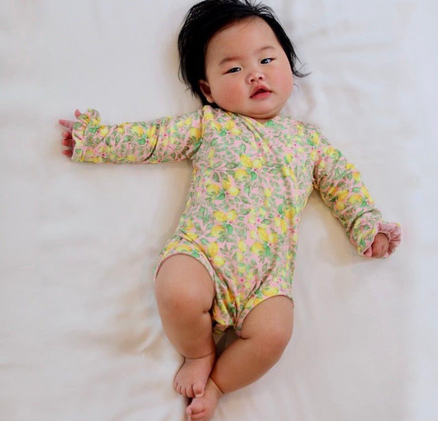 Classic brushed fabric baby bodysuit in Pink Lemonade design with long sleeves, winged, and ruffle cuffs.