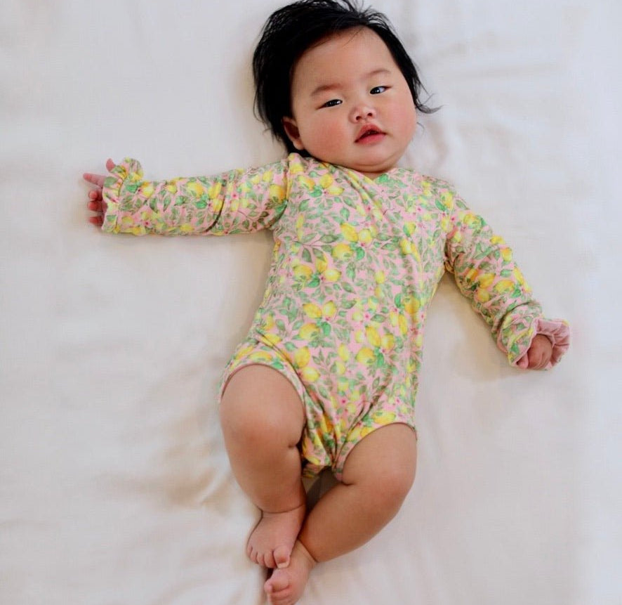 Classic brushed fabric baby bodysuit in Pink Lemonade design with long sleeves, winged, and ruffle cuffs.