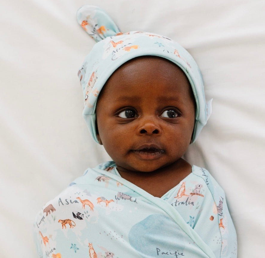 Soft reversible baby beanie in the World Traveler design made from classic brushed fabric.