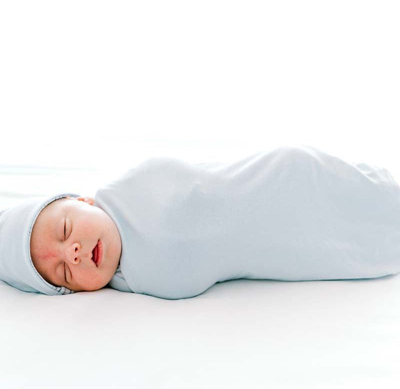 Reversible Bon Voyage design cocoon baby swaddle in bamboo cotton fabric.