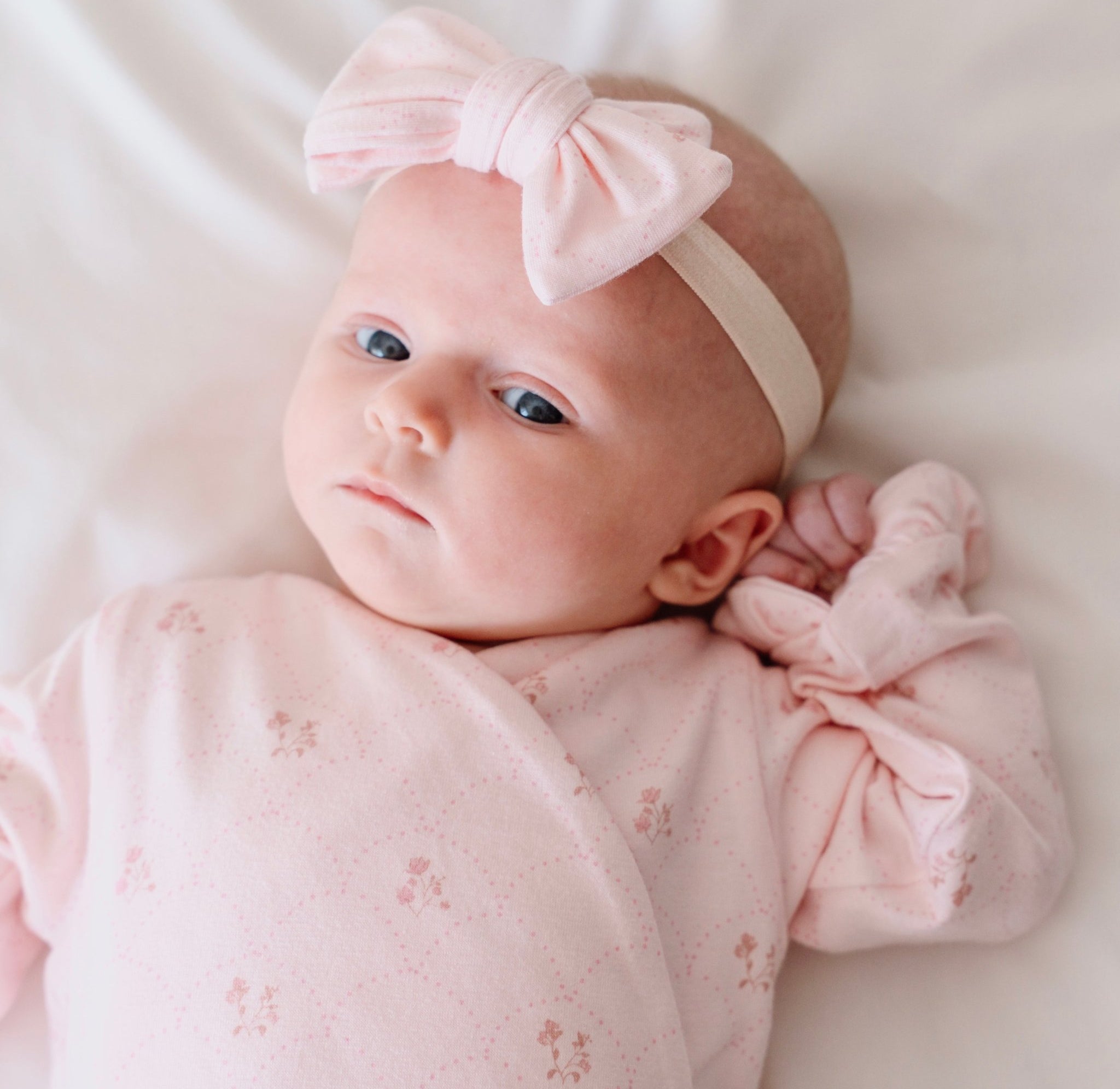 Baby wearing bamboo cotton headband & bow set in dainty dots design.