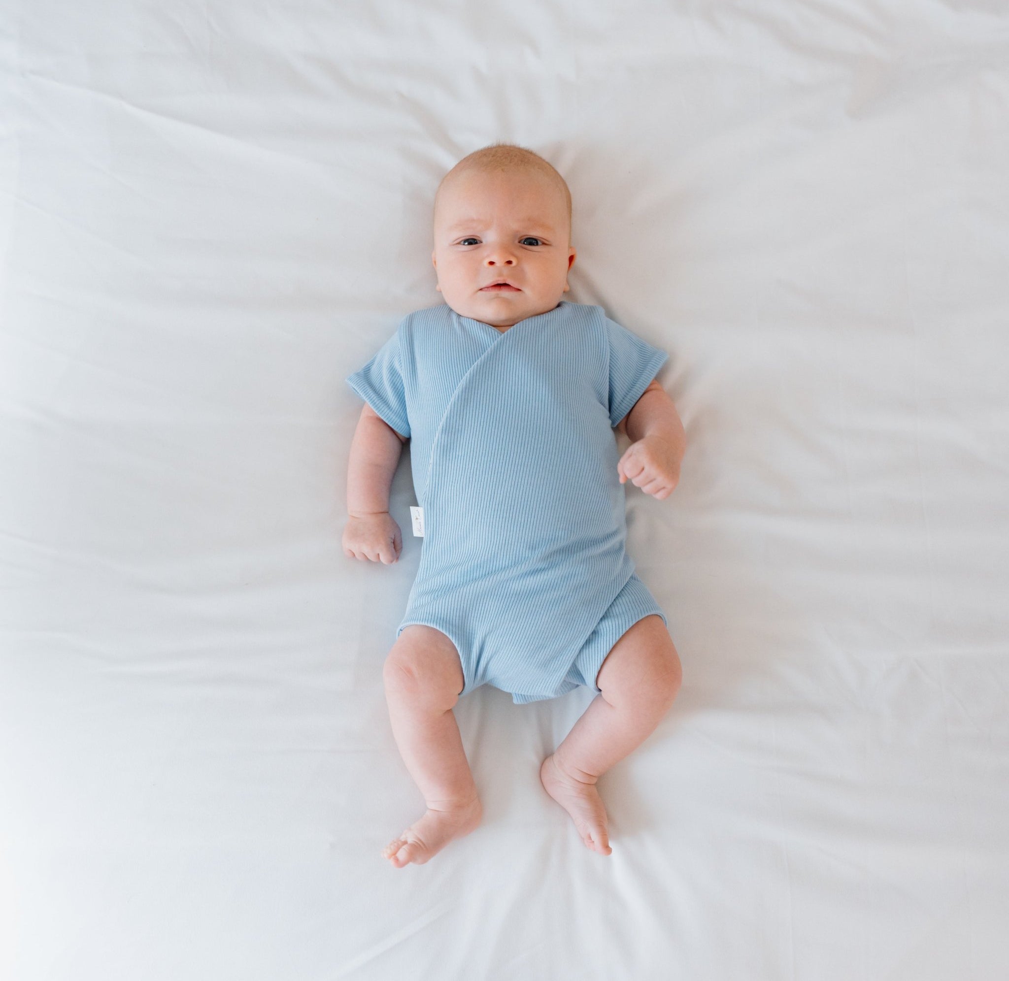 Reversible short sleeve silky modal onesie bodysuit in a dotted blue design.