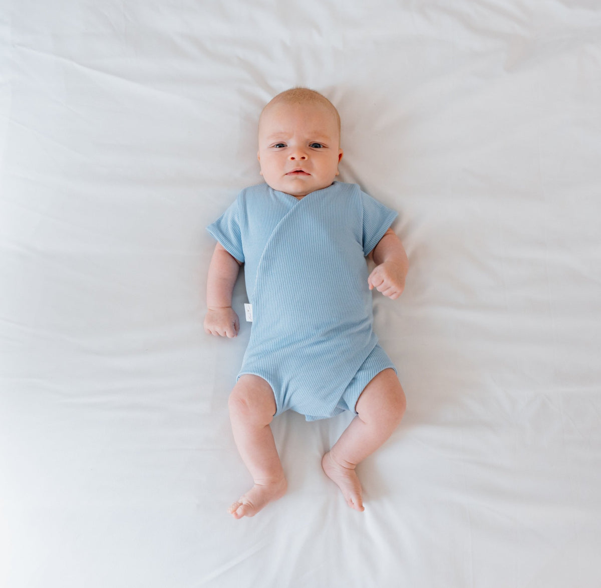 Reversible short-sleeve baby winged bodysuit in dotted blue design.