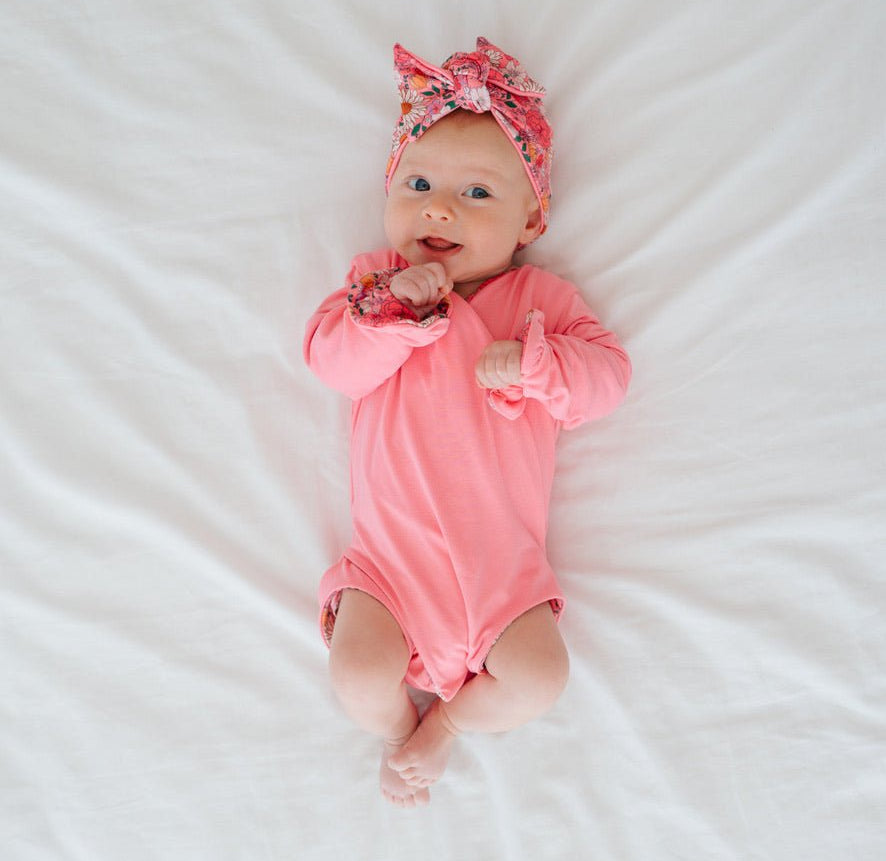 Classic brushed fabric reversible baby bodysuit in Flower Power design with long sleeves, winged details, and ruffle cuffs.