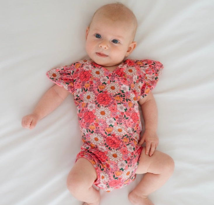 Flower Power short-sleeve bodysuit for baby in Classic Brushed fabric styles with a vibrant floral print.