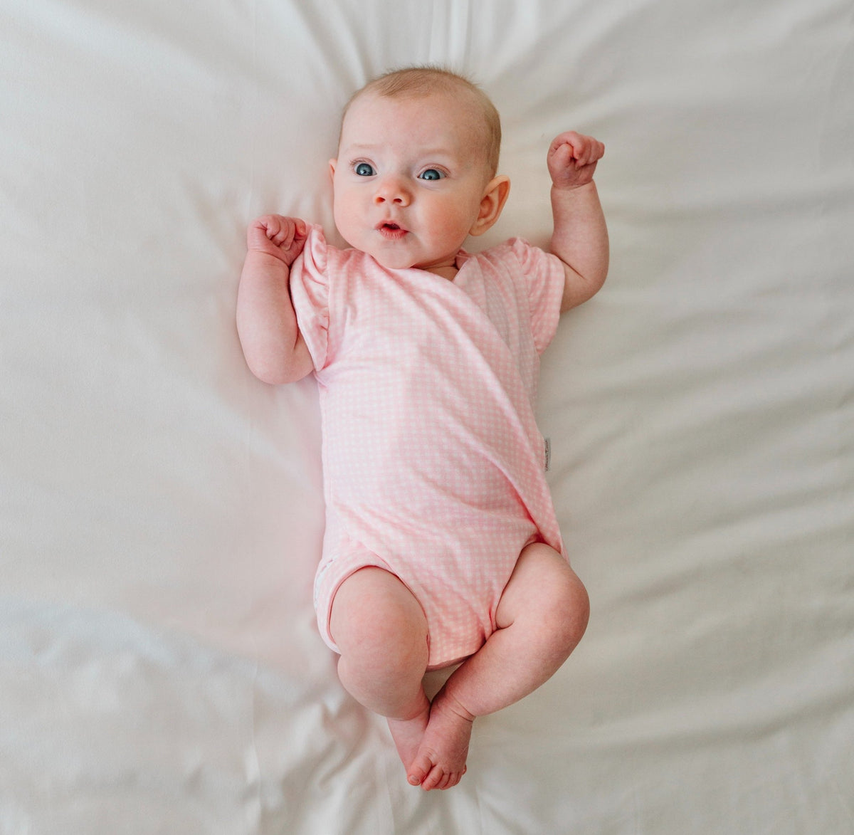 Baby flutter sleeve onesie made from silky modal fabric in Baby Pink Gingham design.