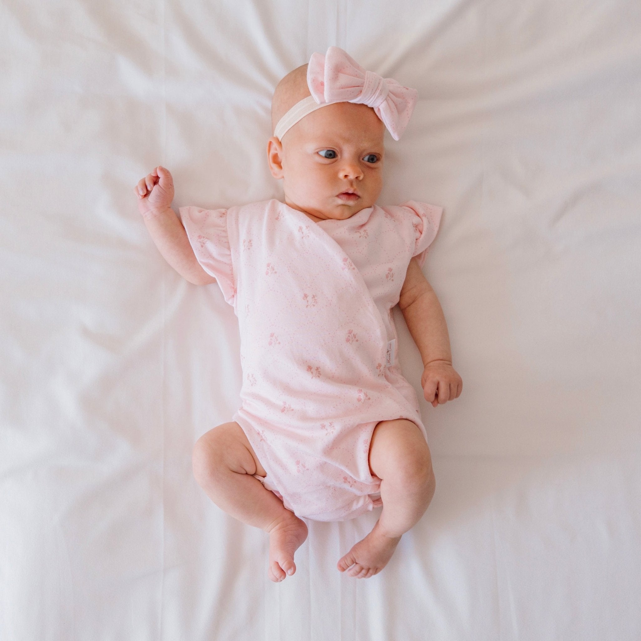 Reversible flutter sleeve winged bodysuit for babies in dainty dots design.