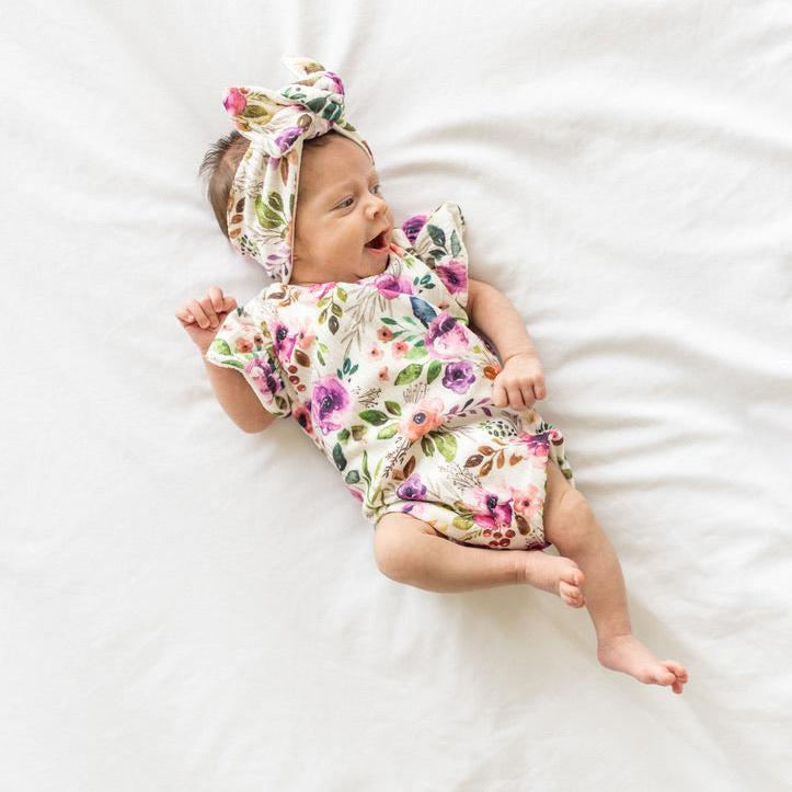Ivory wildflowers design flutter sleeve baby onesie and knotty beanie in classic brushed fabric.