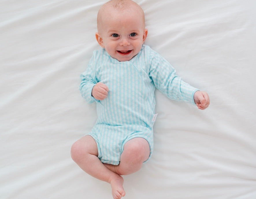 Reversible long-sleeve winged bodysuit in lil surfer design.