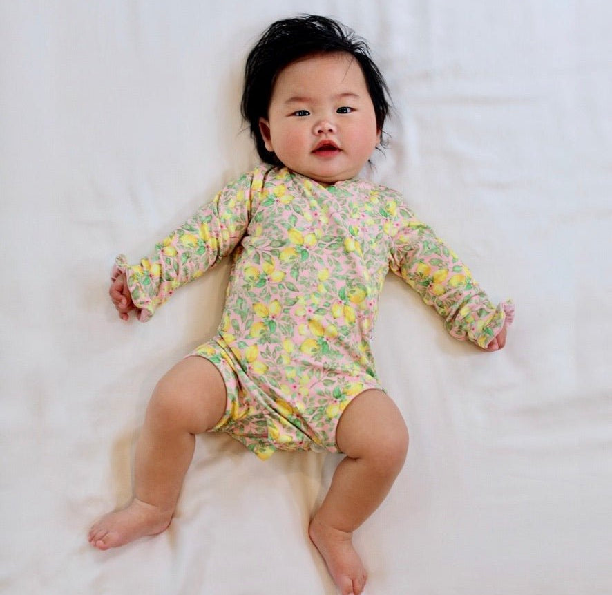 Long sleeve winged baby bodysuit featuring ruffle cuffs in soft Pink Lemonade design brushed fabric.