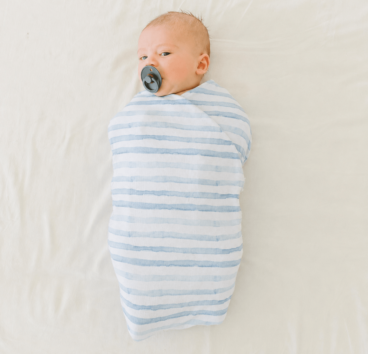 Newborn baby cocoon swaddle featuring Chambray Waves Silky Modal fabric.