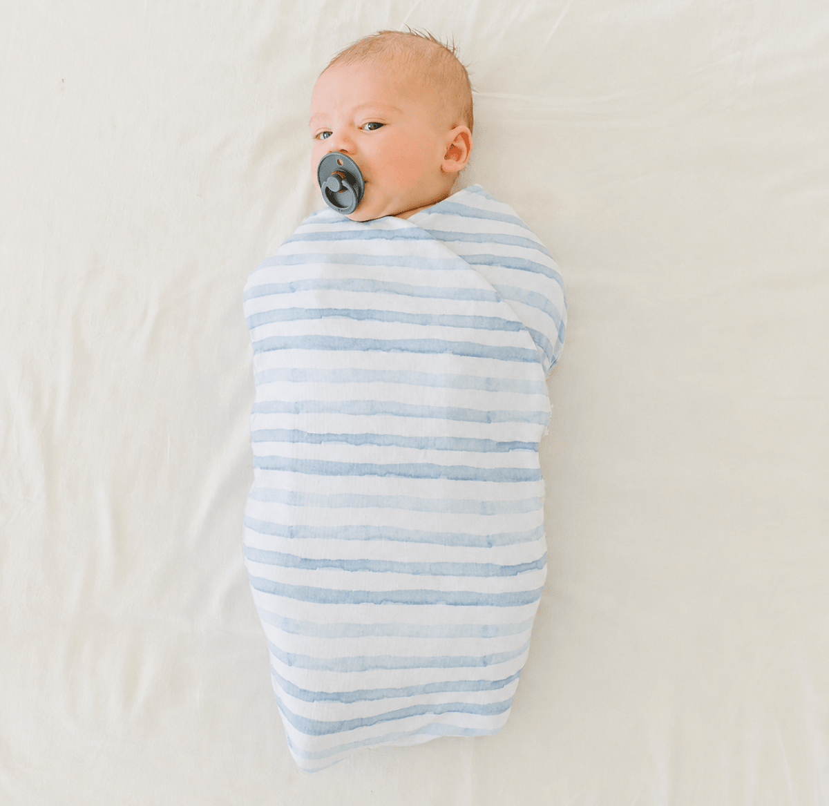 Newborn baby cocoon swaddle featuring Chambray Waves Silky Modal fabric.