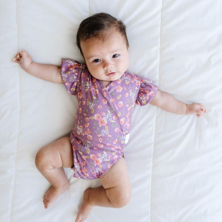 Peachy lilac design flutter sleeve baby onesie and knotty beanie in classic brushed fabric.