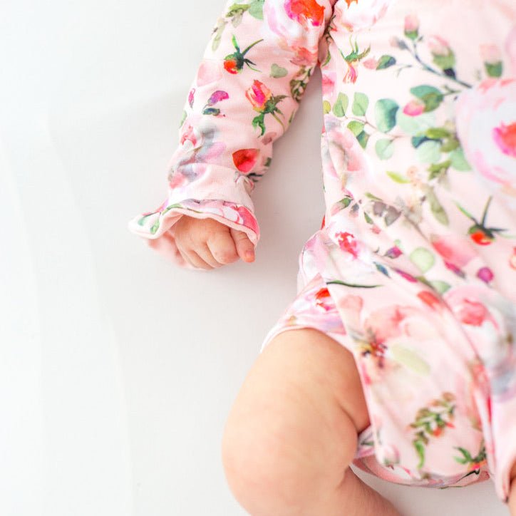 Classic brushed fabric baby bodysuit in Peachy Rose Fields design with long sleeves, winged, and ruffle cuffs.