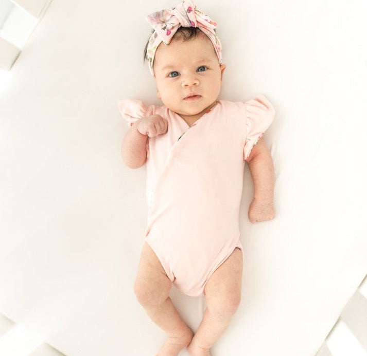 Reversible boutique baby bodysuit in Peachy Rose Fields print and Classic Brushed fabric styles.