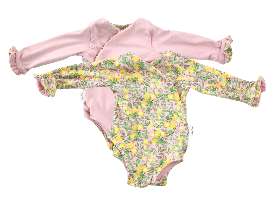 Reversible pink lemonade long sleeve ruffle cuff baby onesie.