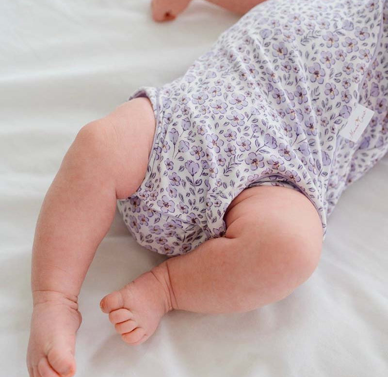 Purple Posies design flutter sleeve winged bodysuit for babies in silky modal fabric.