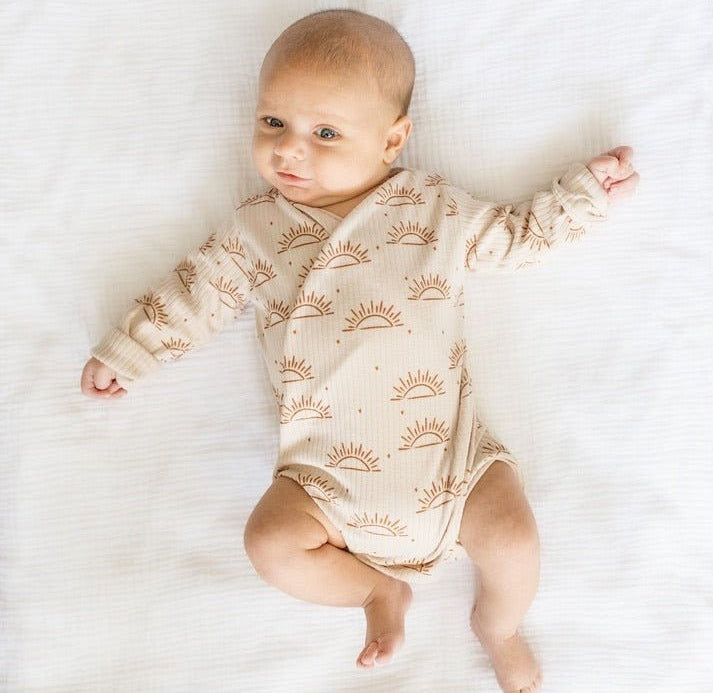Reversible long-sleeve winged bodysuit in sandy sunsets design.