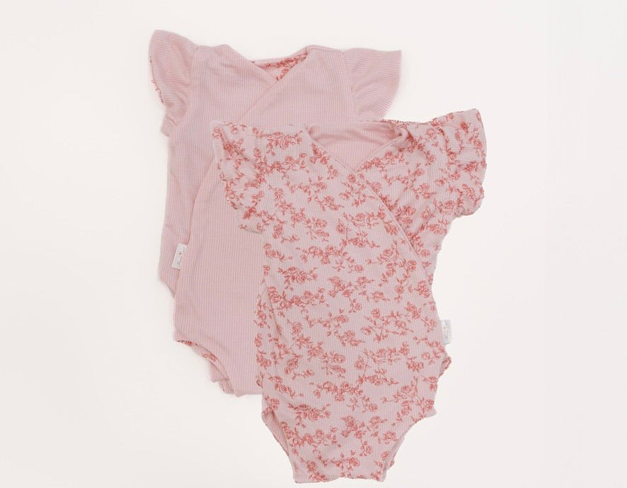 Reversible bitty pink blooms design flutter sleeve baby onesie in silky modal fabric.
