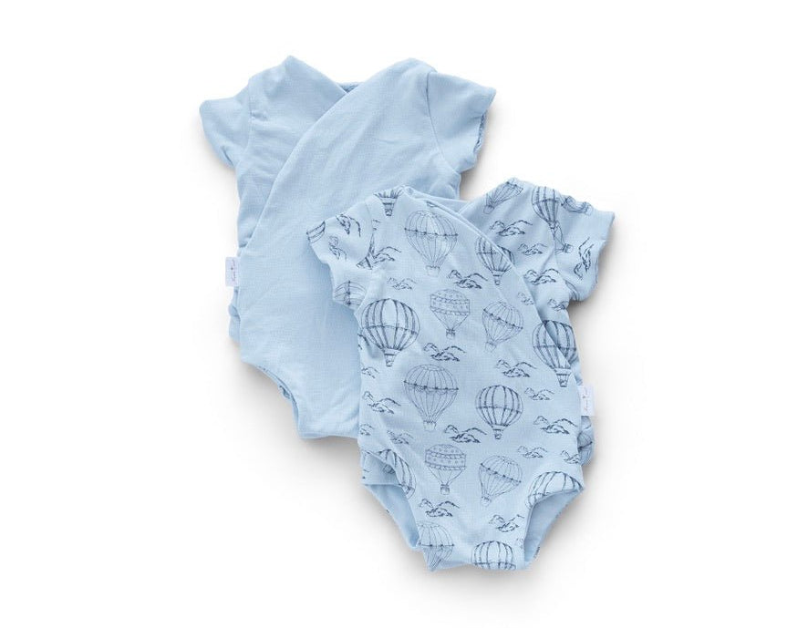 Reversible bon voyage design short-sleeve baby onesie in bamboo cotton fabric.
