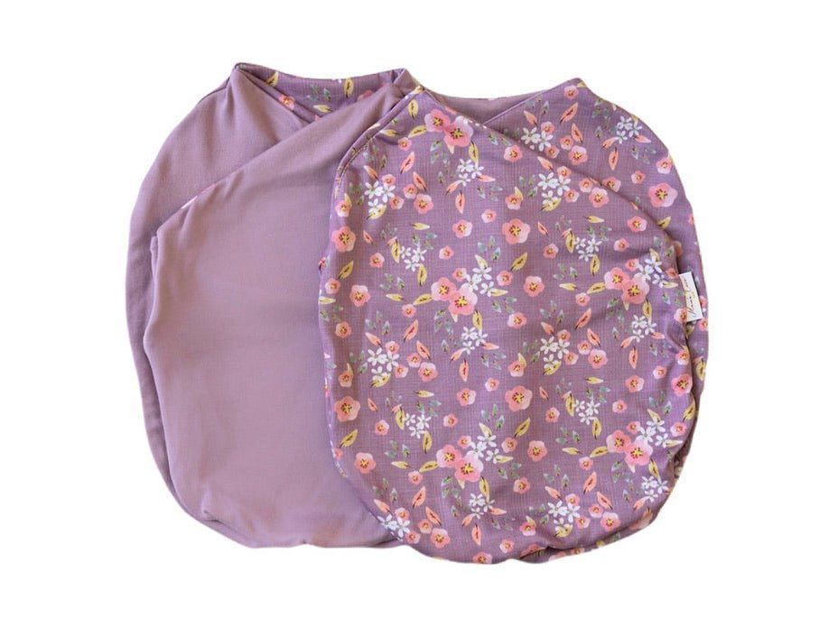 Reversible peachy lilac design cocoon baby swaddle in classic brushed fabric.