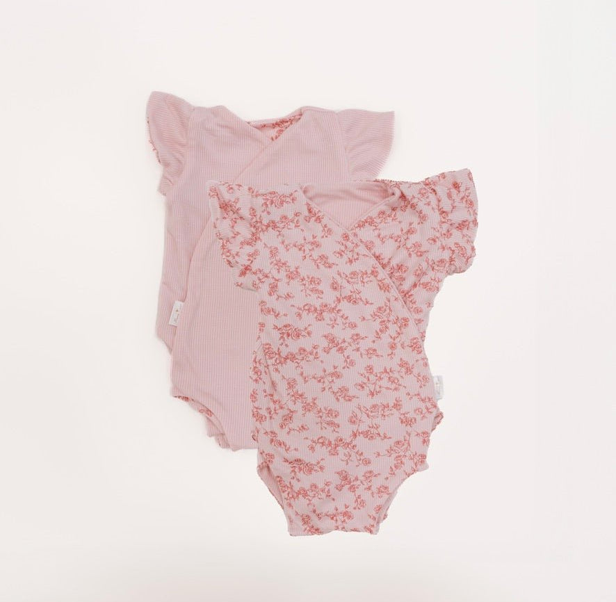Reversible flutter sleeve baby onesie in bitty pink blooms design.