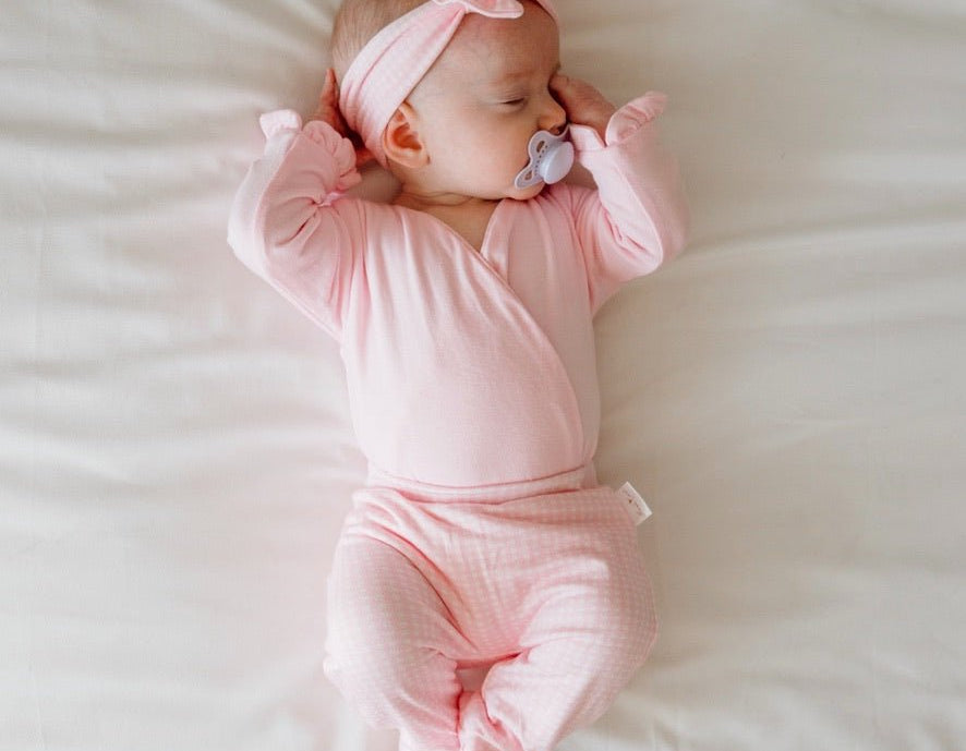 Soft and gentle baby footie pants made from silky modal fabric in the Baby Pink Gingham design.