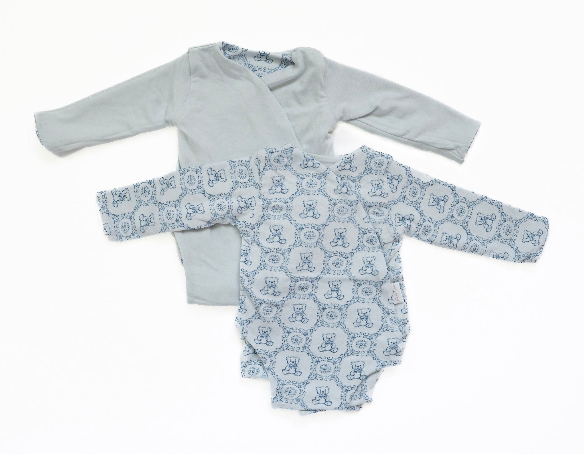 Reversible long-sleeve baby onesie in teddy tiles design.