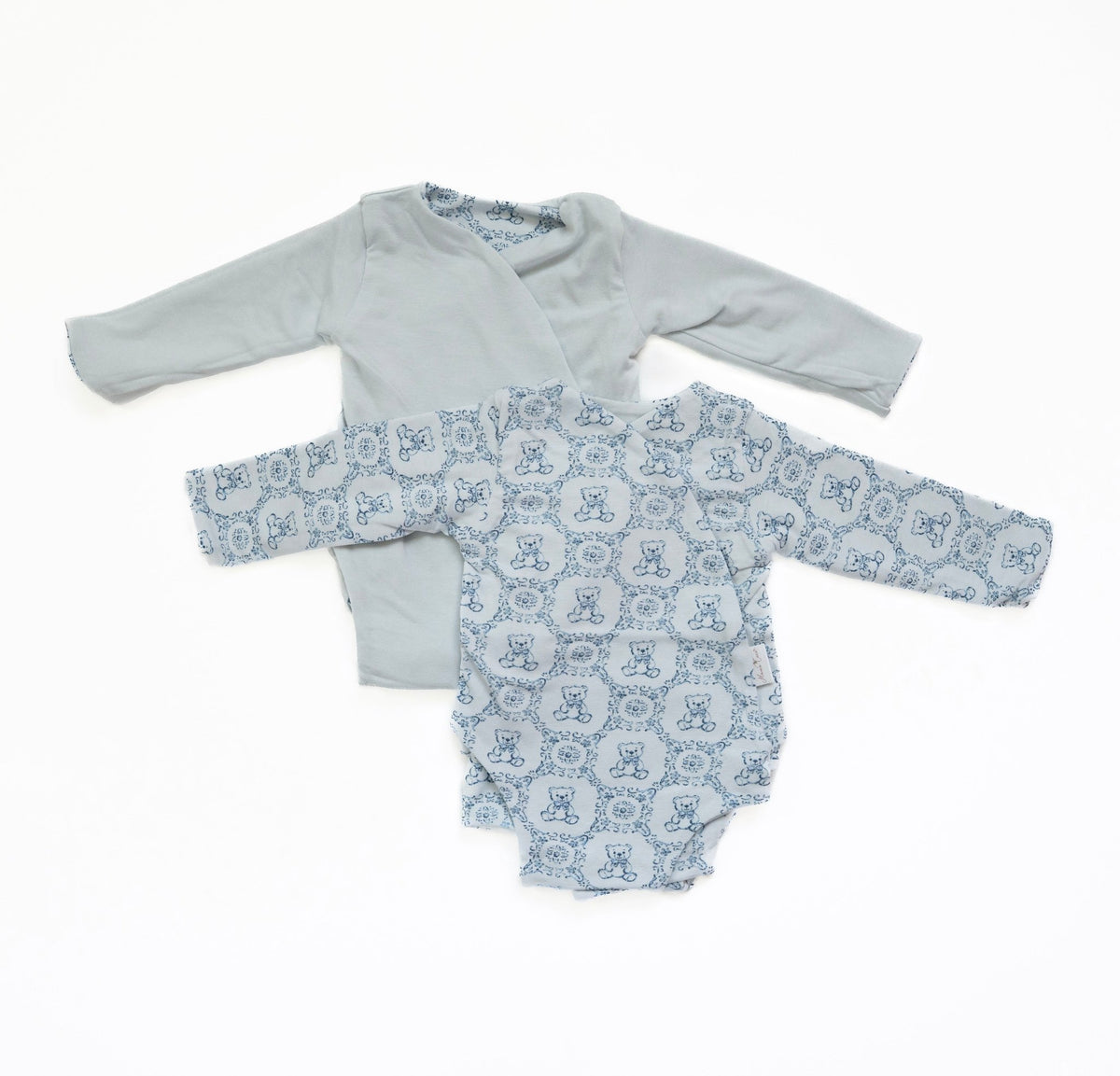 Reversible long-sleeve baby onesie in teddy tiles design.