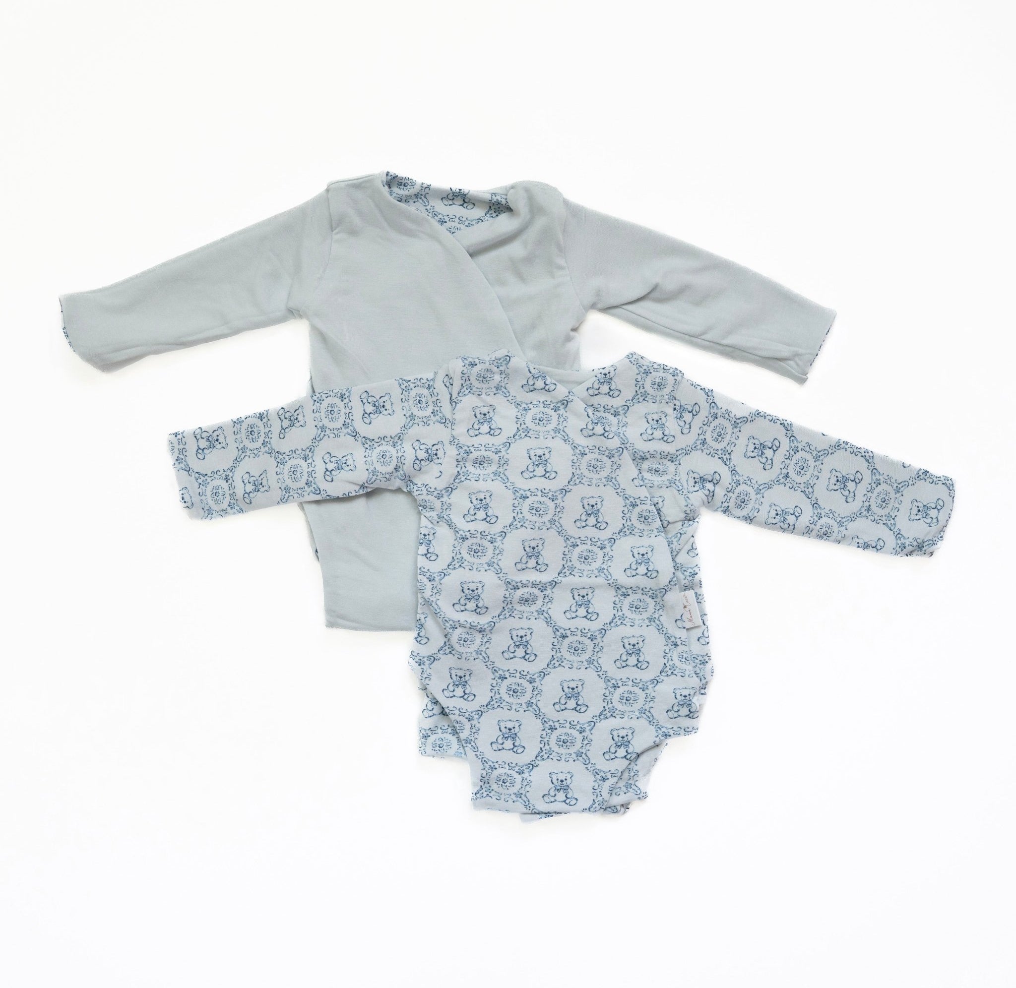 Reversible long-sleeve baby onesie in teddy tiles design.